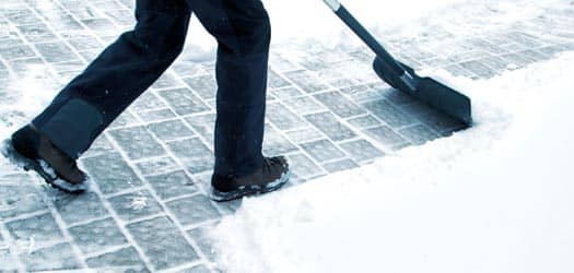 Person shoveling snow off walkway